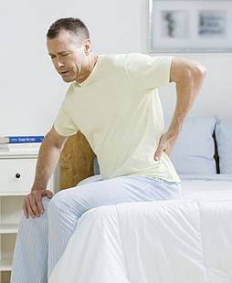 Man in bed with back pain